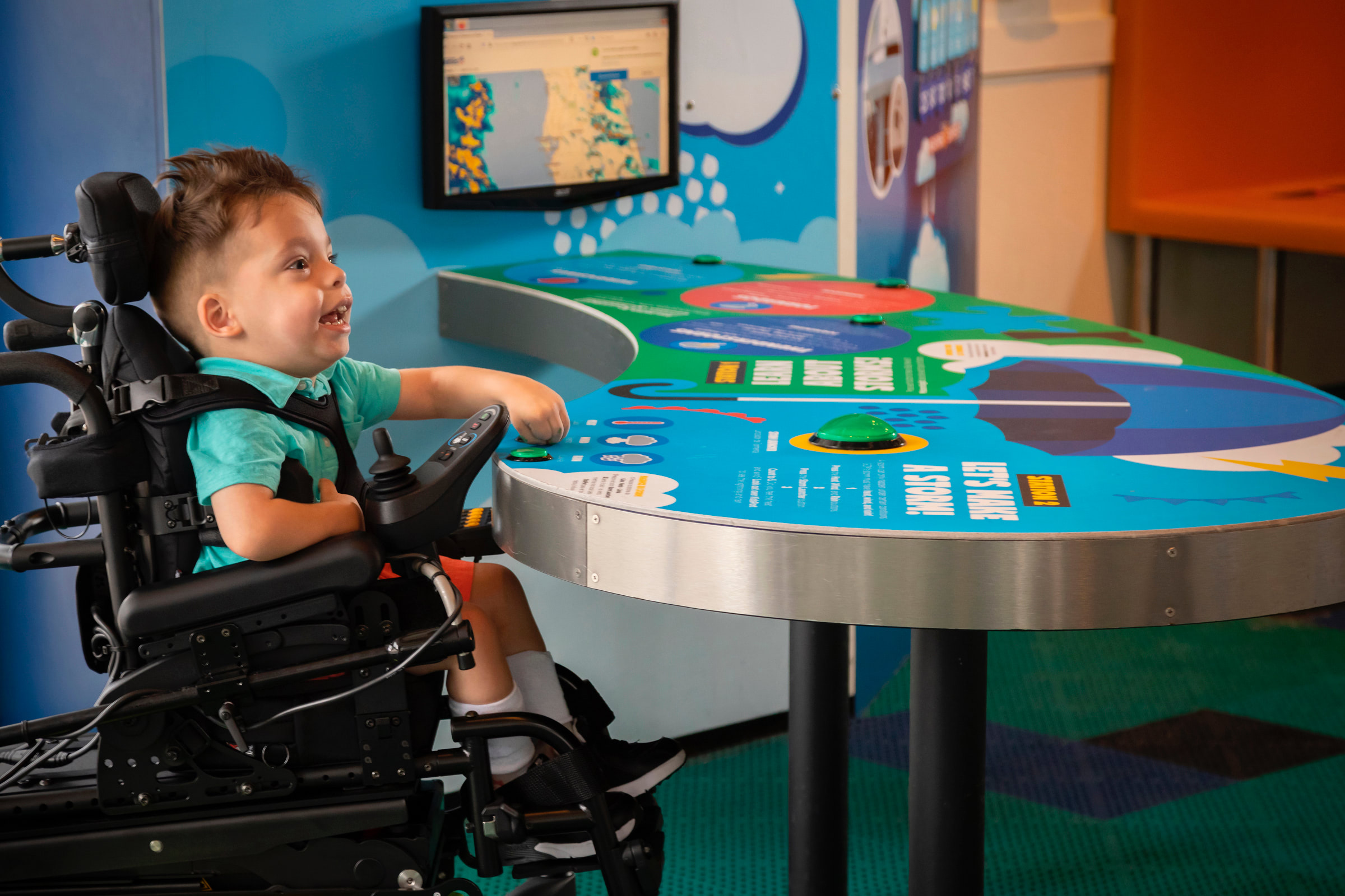 Child with disability playing at an interactive station at GCM