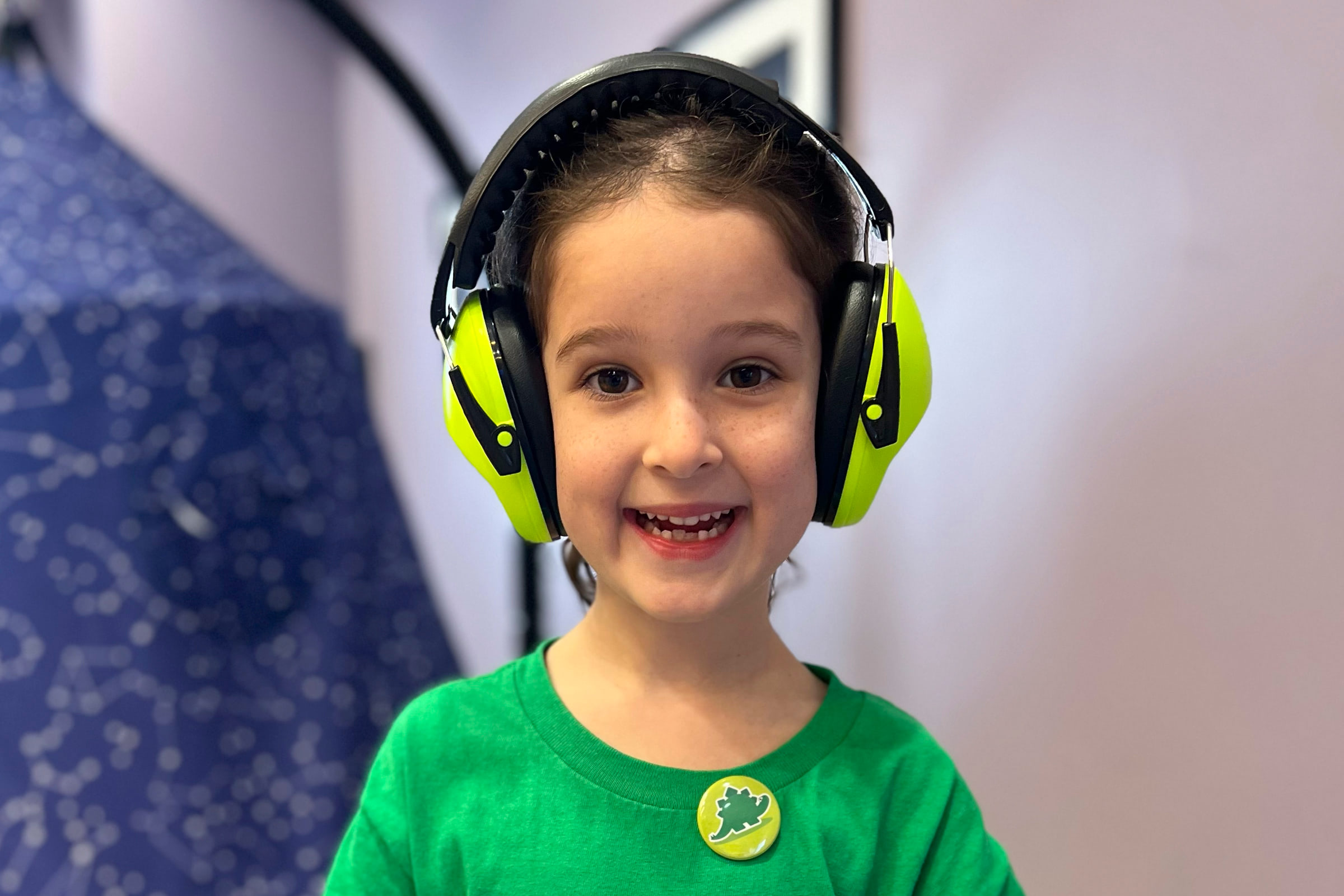 Child wearing protective headphones and smiling