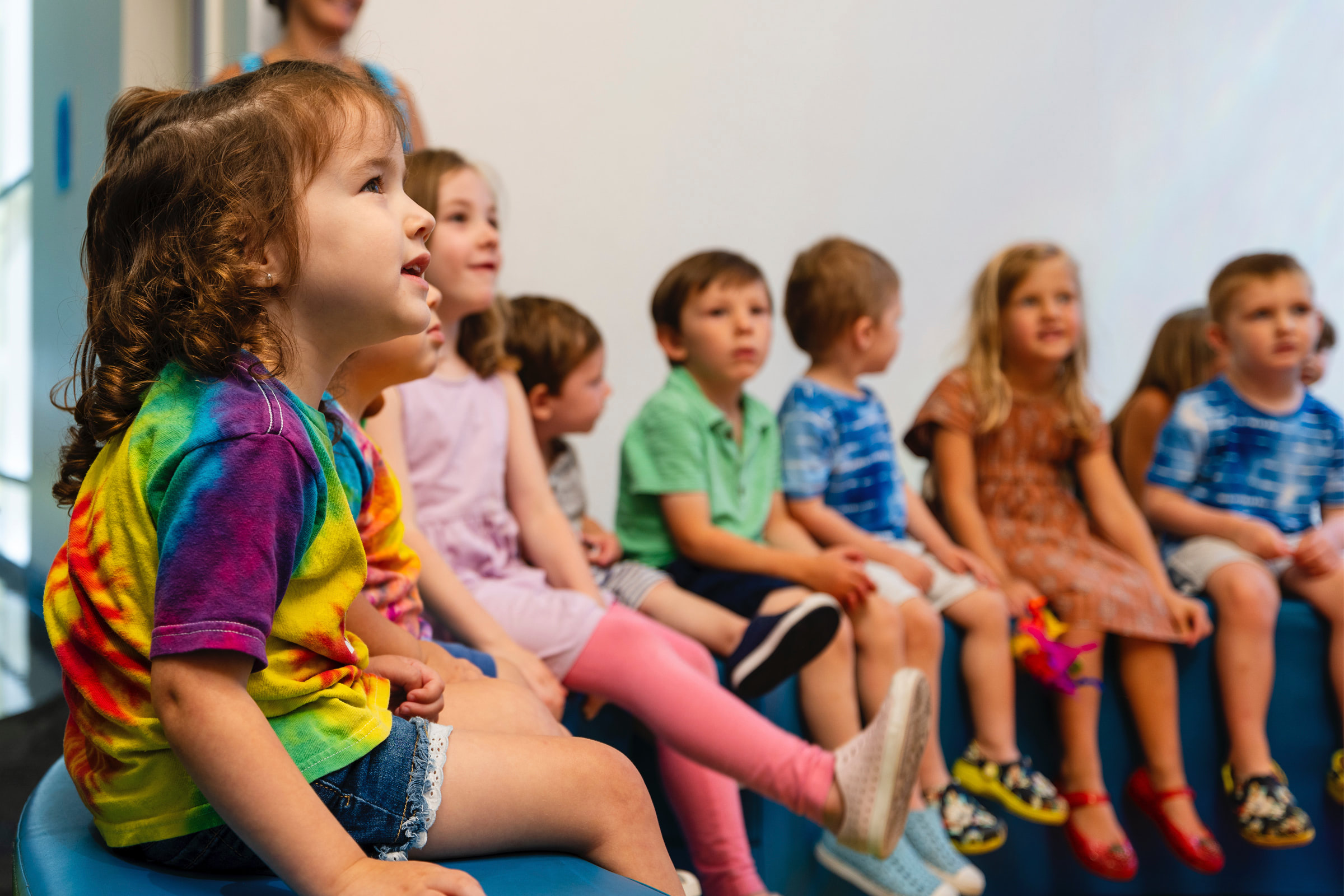 Group of children smiling and listening to a presentation