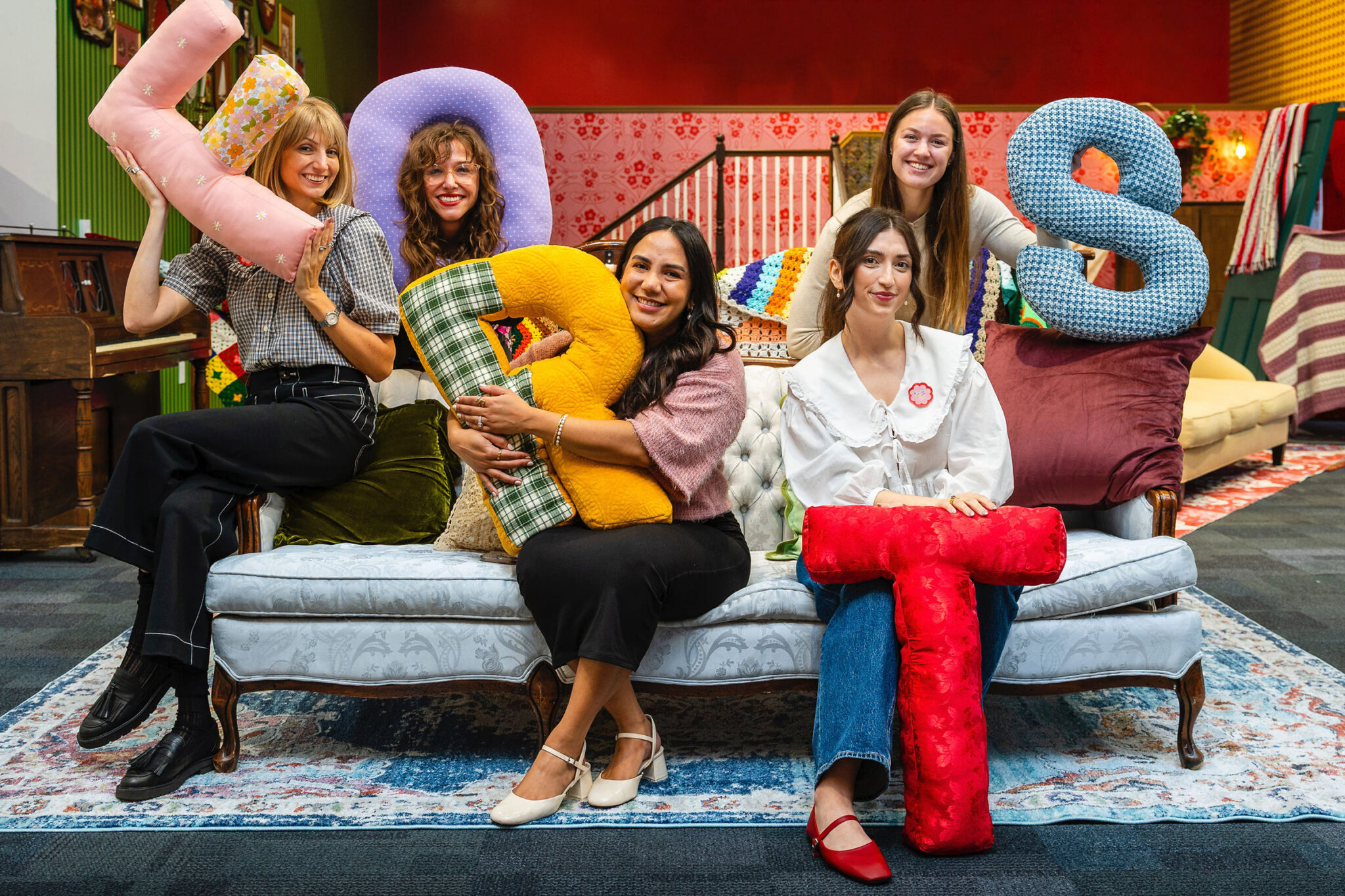 five people on a couch with pillows spelling FORTS