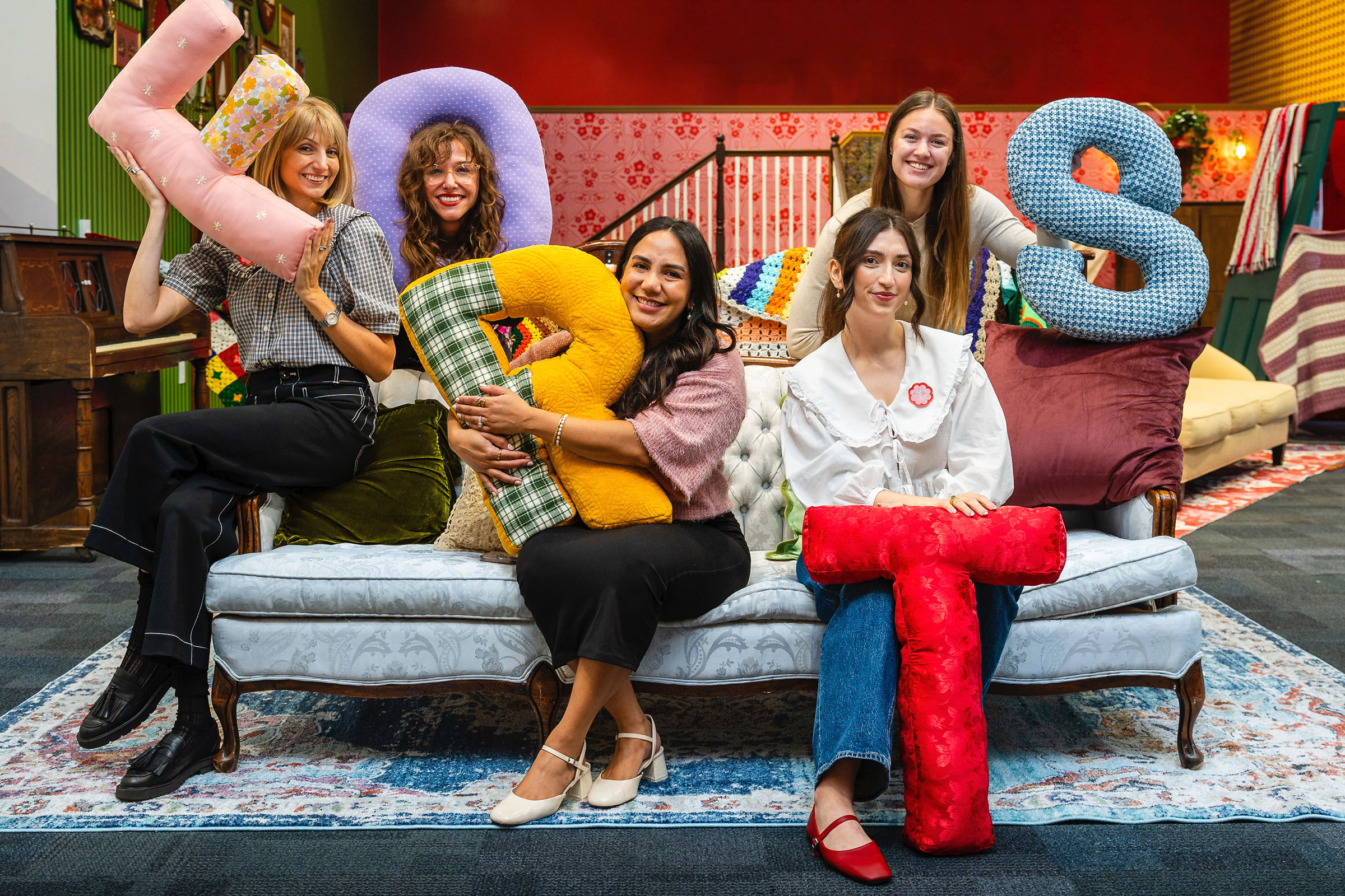 five people on a couch with pillows spelling FORTS