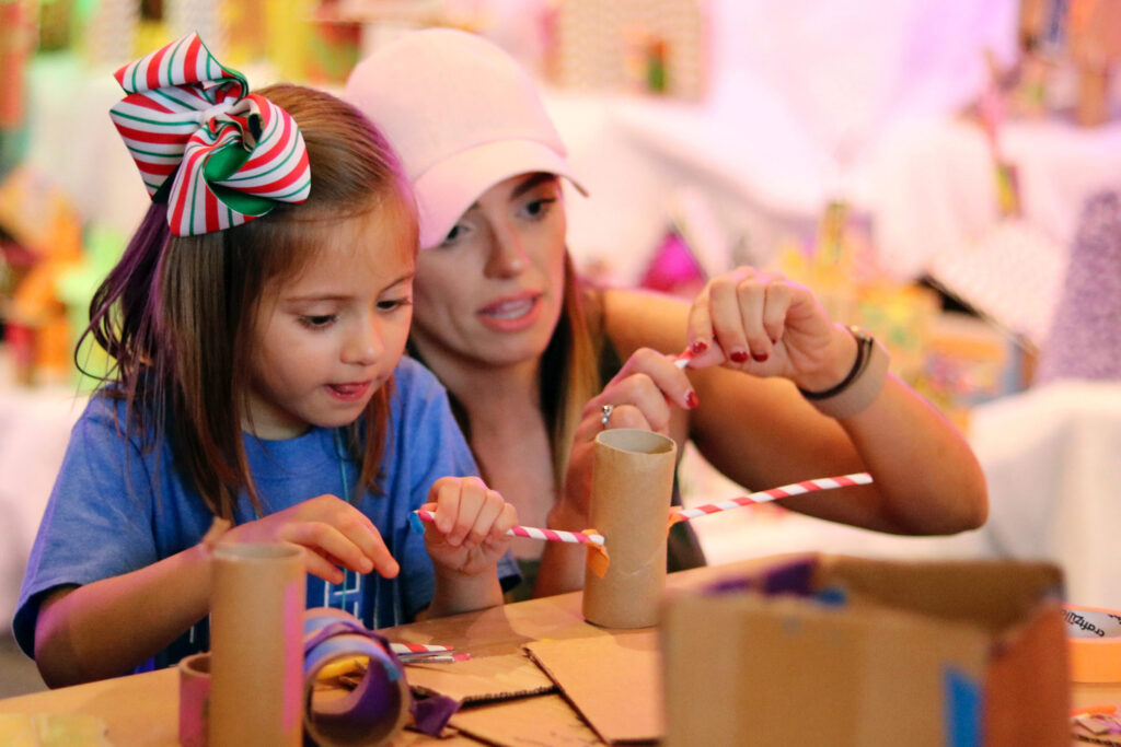 Parent helping child make a craft