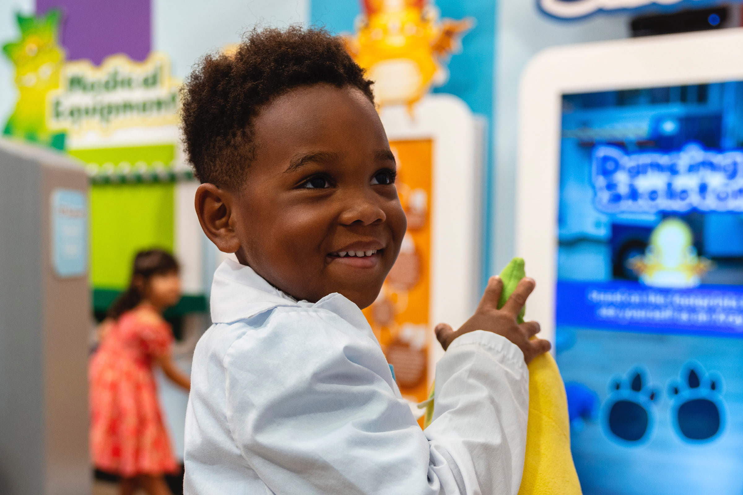 Child holding stuffed animal and smiling