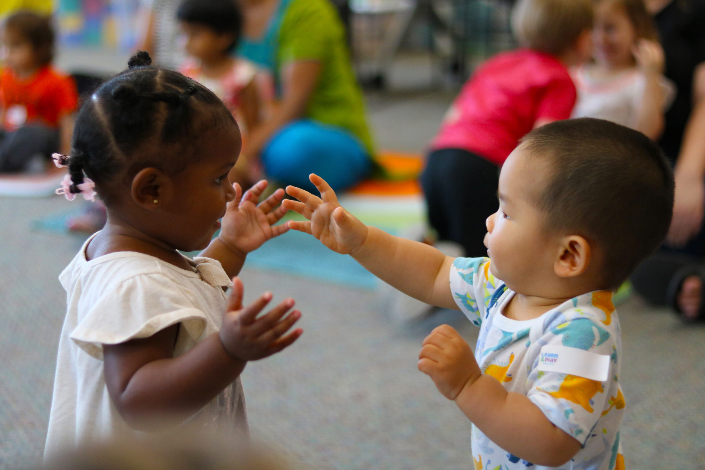 two toddlers facing each other while playing