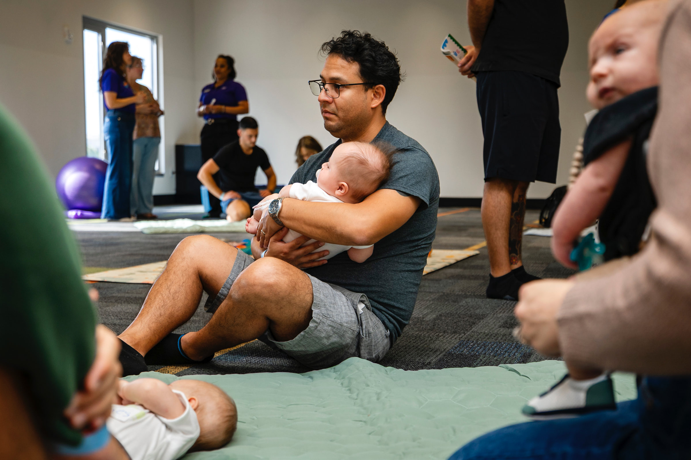parents and babies sitting and laying on the floor together