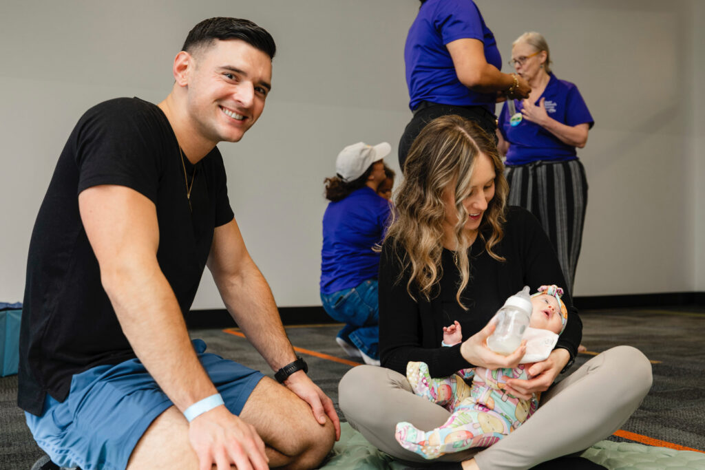parents sitting on the floor holding a baby