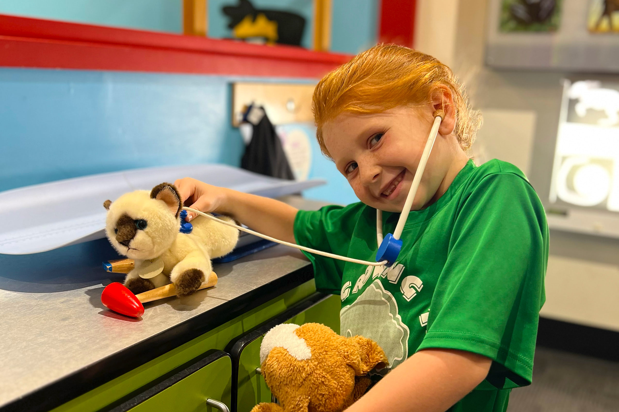 little kid playing with stuffed animals like a vet
