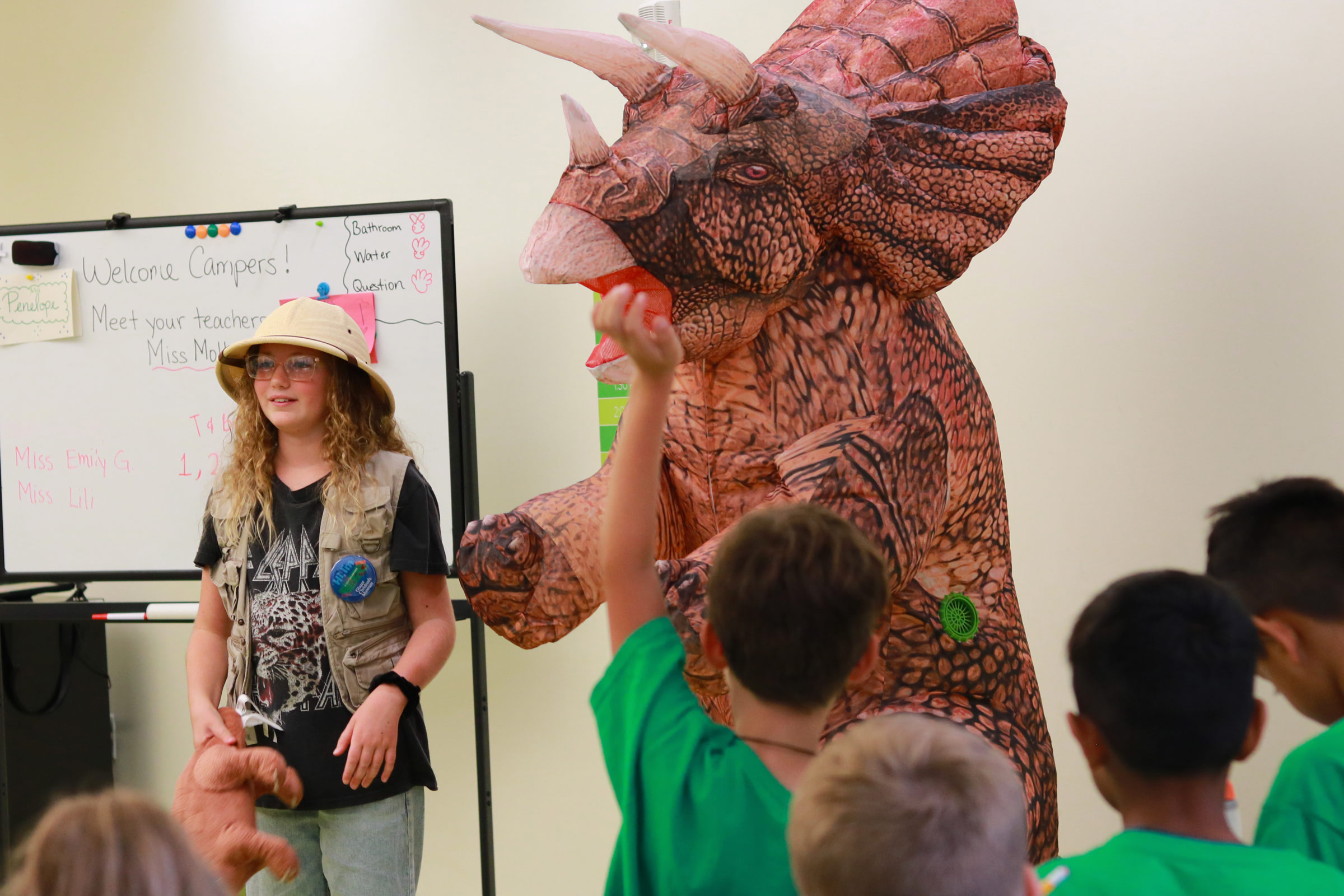 person standing next to someone in a dinosaur costume